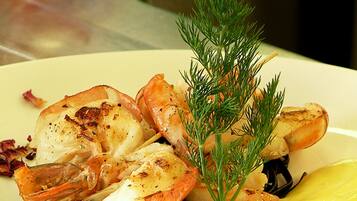 A plate of grilled shrimp and scallops garnished with dill.