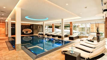 Una piscina techada, sillones reclinables de piscina
