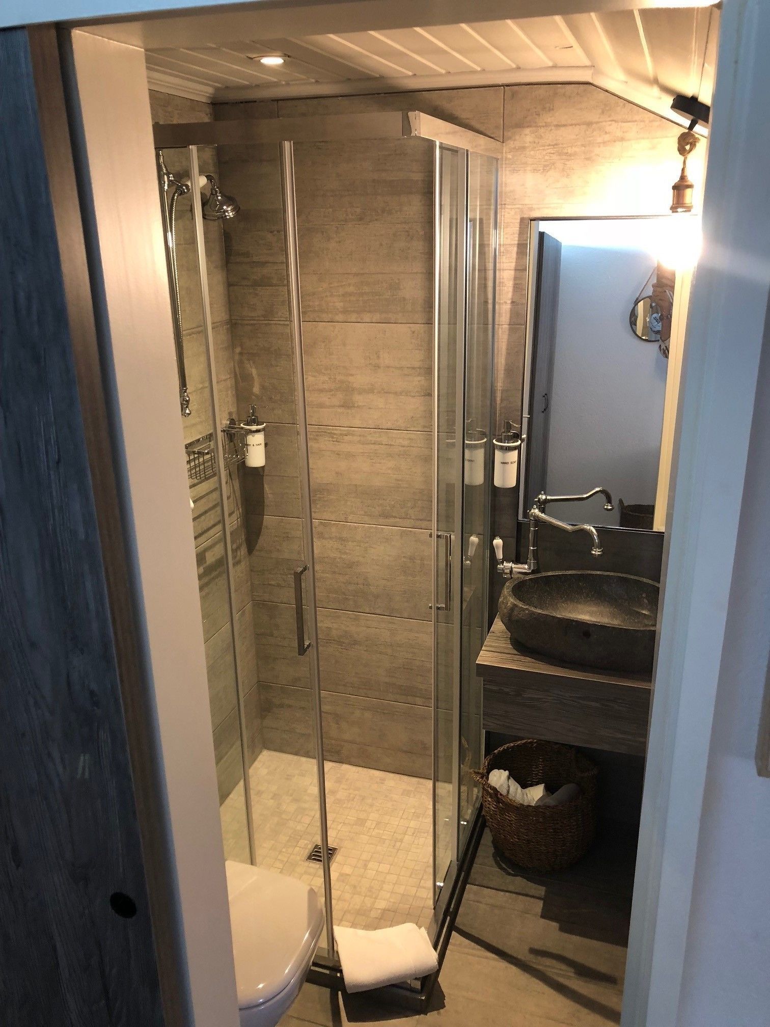 Un baño moderno con cabina de ducha de vidrio, lavabo empotrado y retrete.
