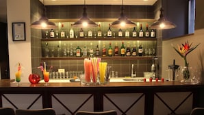 A bar area with multiple liquor bottles, a variety of glasses, and a decorative plant. - Hotel Le Maritime (Istanbul)