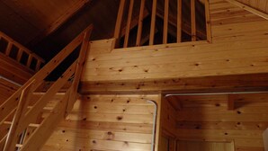 A wooden staircase with a handrail leading to an upper level. - Camping Morunys (Sant Llorenc de Morunys)