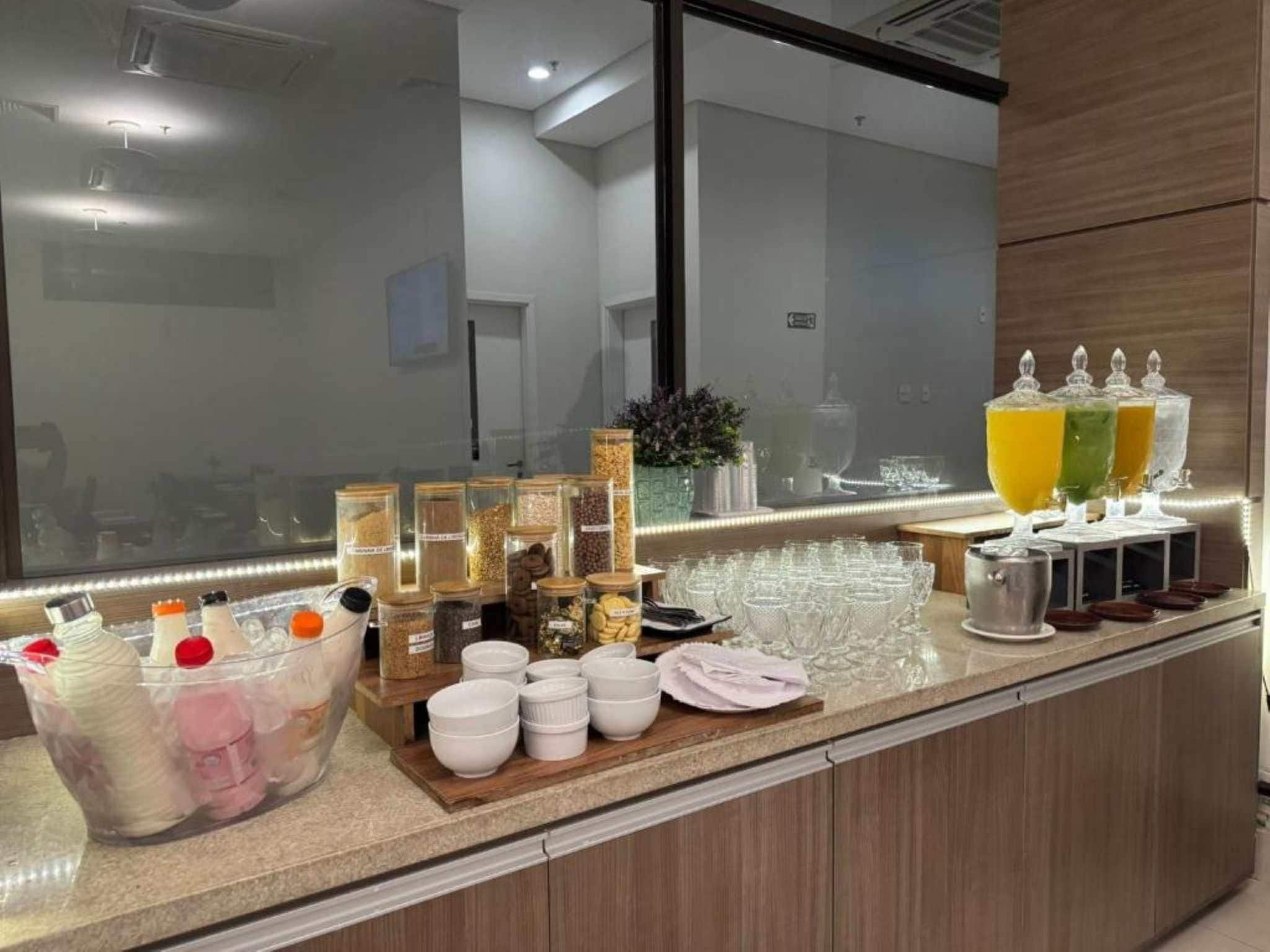 Zona de buffet con diferentes recipientes de comida, tazones y una estación de bebidas.