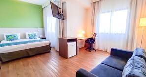 A hotel room with a bed, desk, chair, and a sofa. - Blue Tree Towers Valinhos (Valinhos)