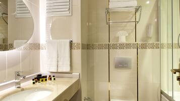 Un baño moderno con un lavamanos grande, espejo, inodoro y ducha.