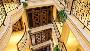 A multi-level atrium with ornate railings, decorative columns, and a central star-shaped floor design. - Black Bird Thermal Hotel & Spa (Termal)