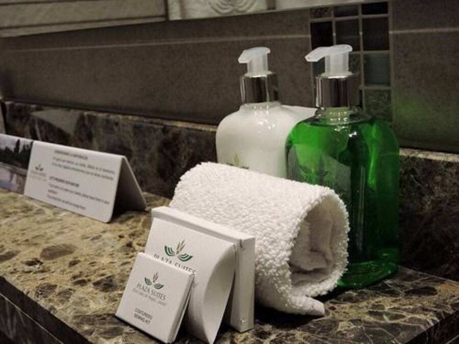 Un meuble-lavabo dans une salle de bain, avec des articles de toilette, une serviette blanche et un panneau.