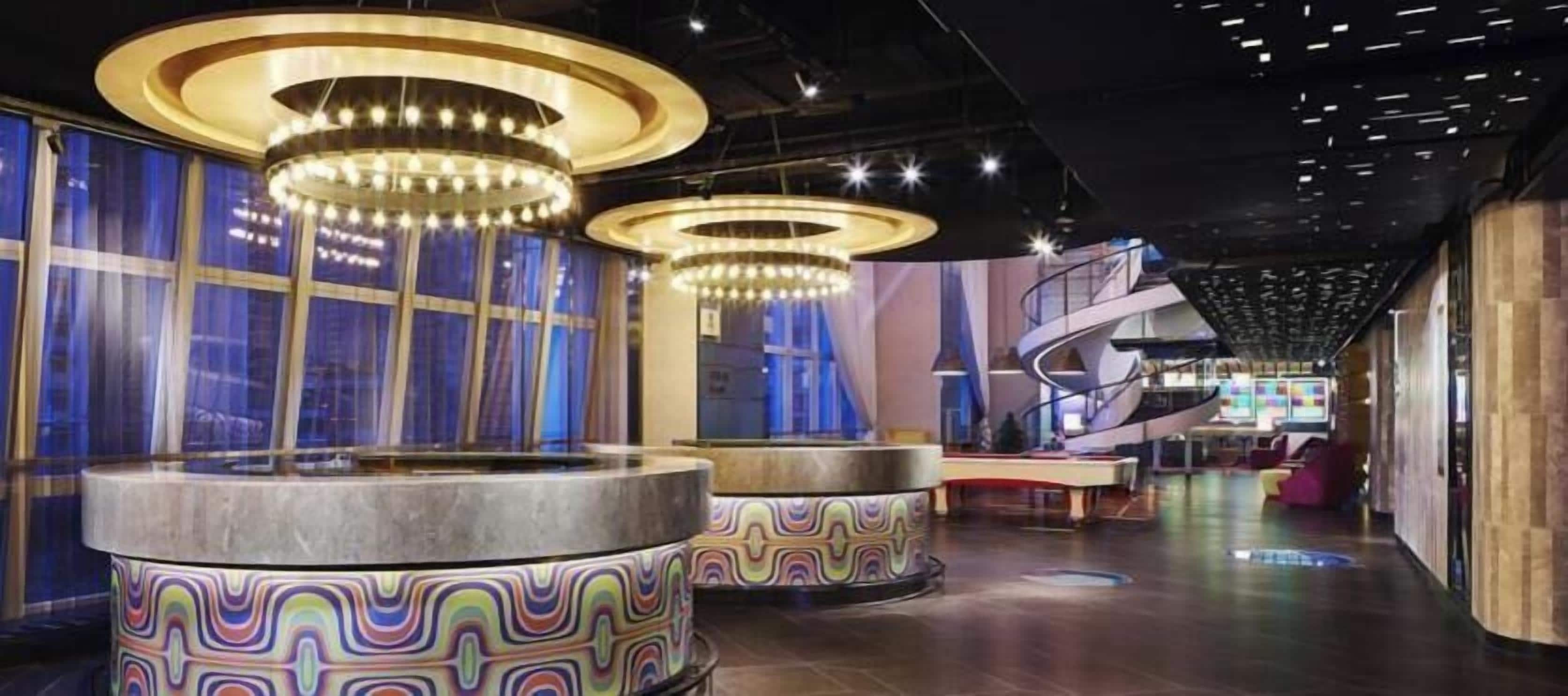 En moderne lobby med runde siddepladser, en spiraltrappe og en receptionsdisk.