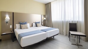 A hotel room with two beds, a desk, and a chair. - Hotel Route 42 (Illescas)
