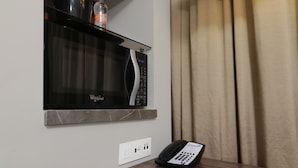 A kitchen with a microwave, a water bottle, and a phone on a counter. - Holiday Inn Express & Suites Monterrey Valle by IHG (San Pedro Garza García)