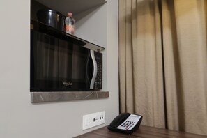 A kitchen with a microwave, a water bottle, and a phone on a counter. - Holiday Inn Express & Suites Monterrey Valle by IHG (San Pedro Garza García)