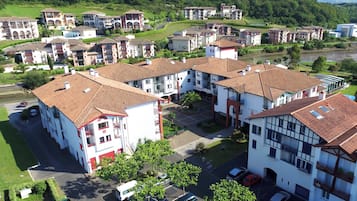Zona residencial con varios edificios de dos pisos, un patio central y un río al fondo.