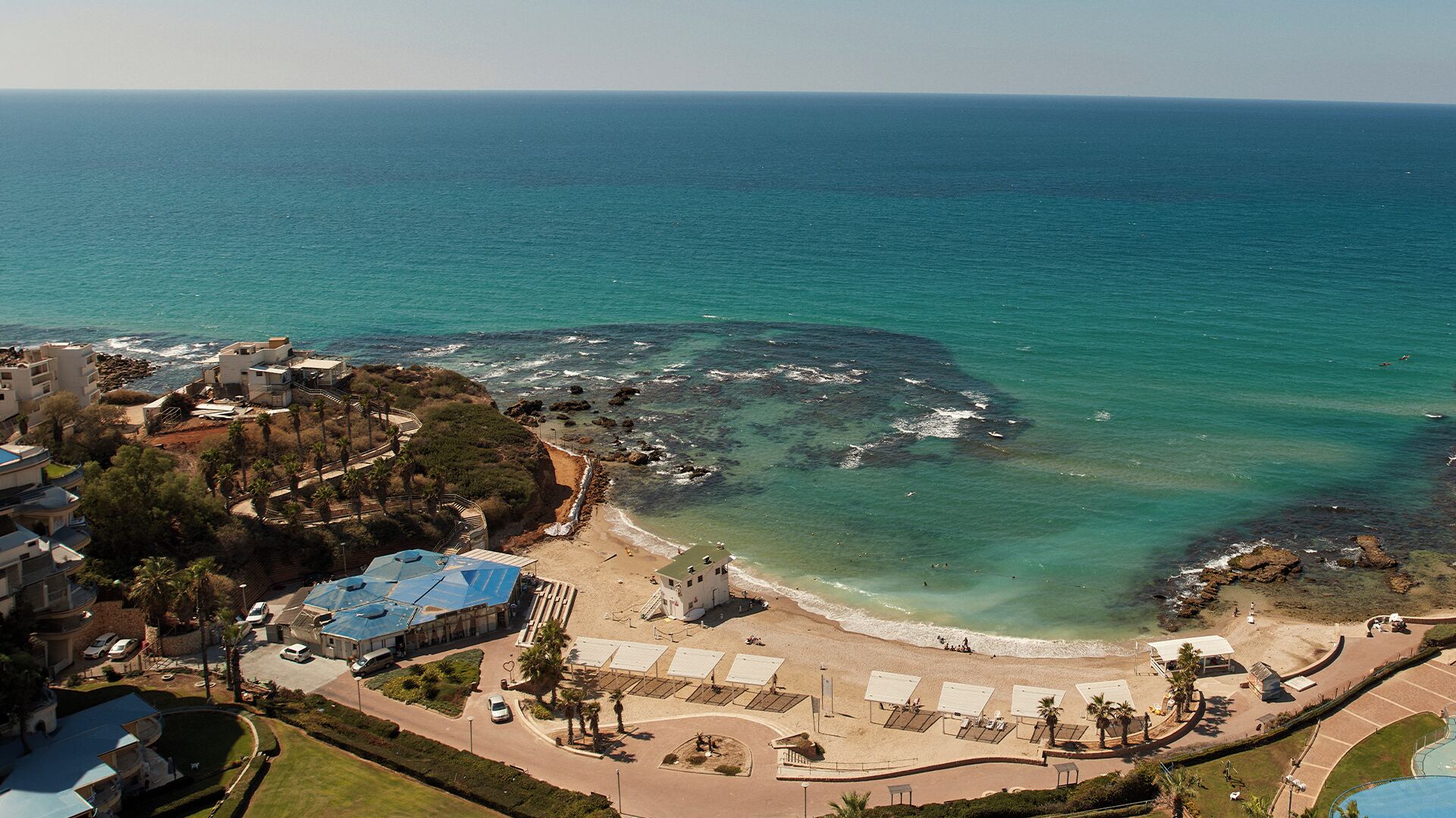 A coastal hotel with a beach, ocean views, and a pool.