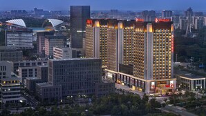 Un hotel moderno de gran altura, con una fachada destacada e iluminación de señalización.