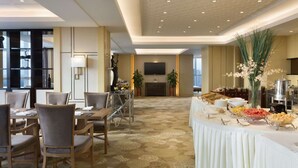 Un vestíbulo de hotel con zona de comedor, chimenea y bufé.