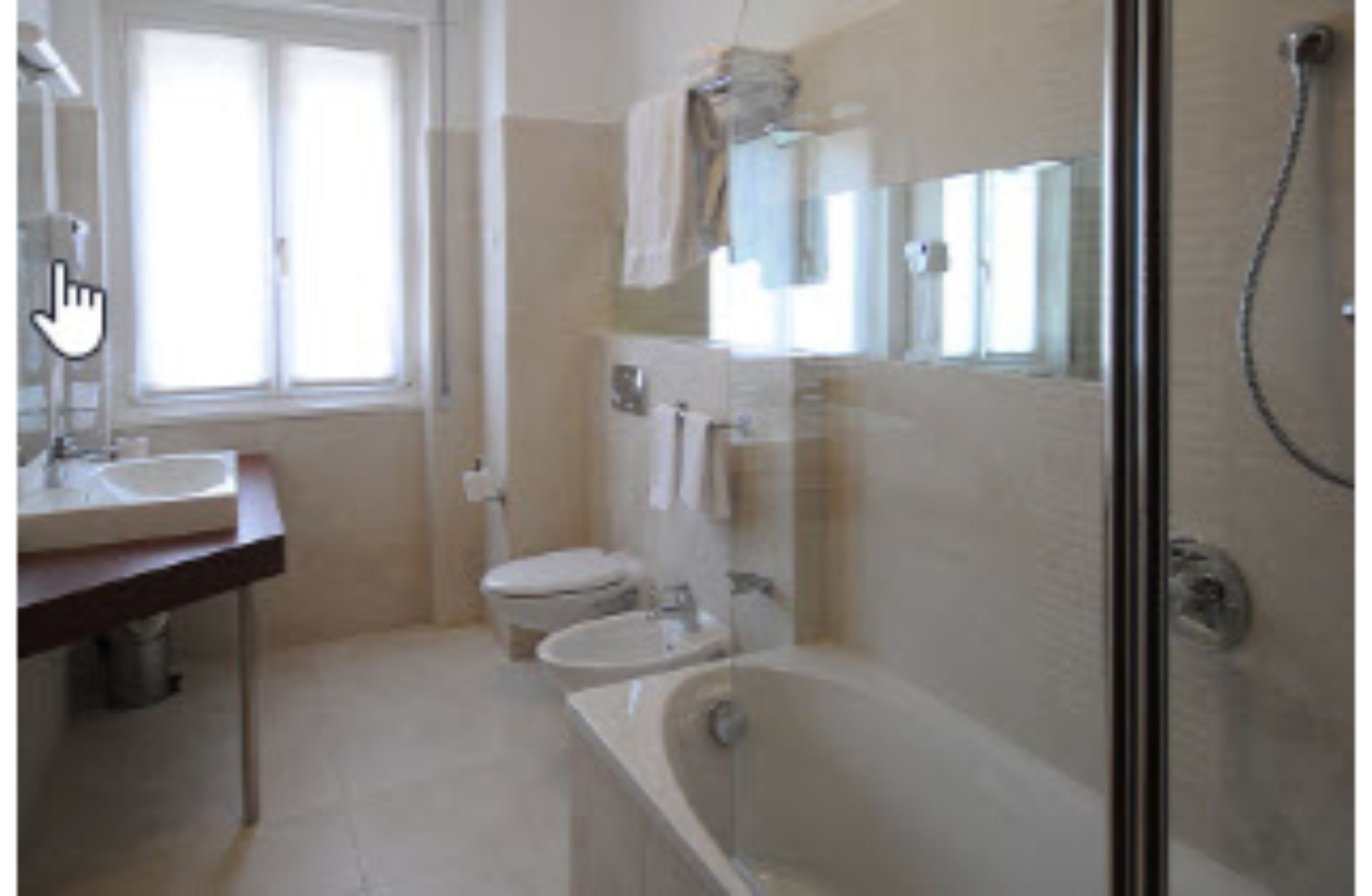 A bathroom with a bathtub, two toilets, a sink, and a window.
