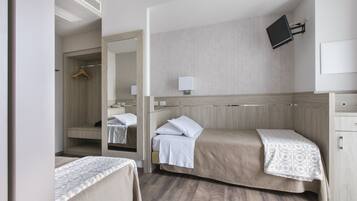 Habitación de hotel con dos camas, un espejo, un televisor y un armario.