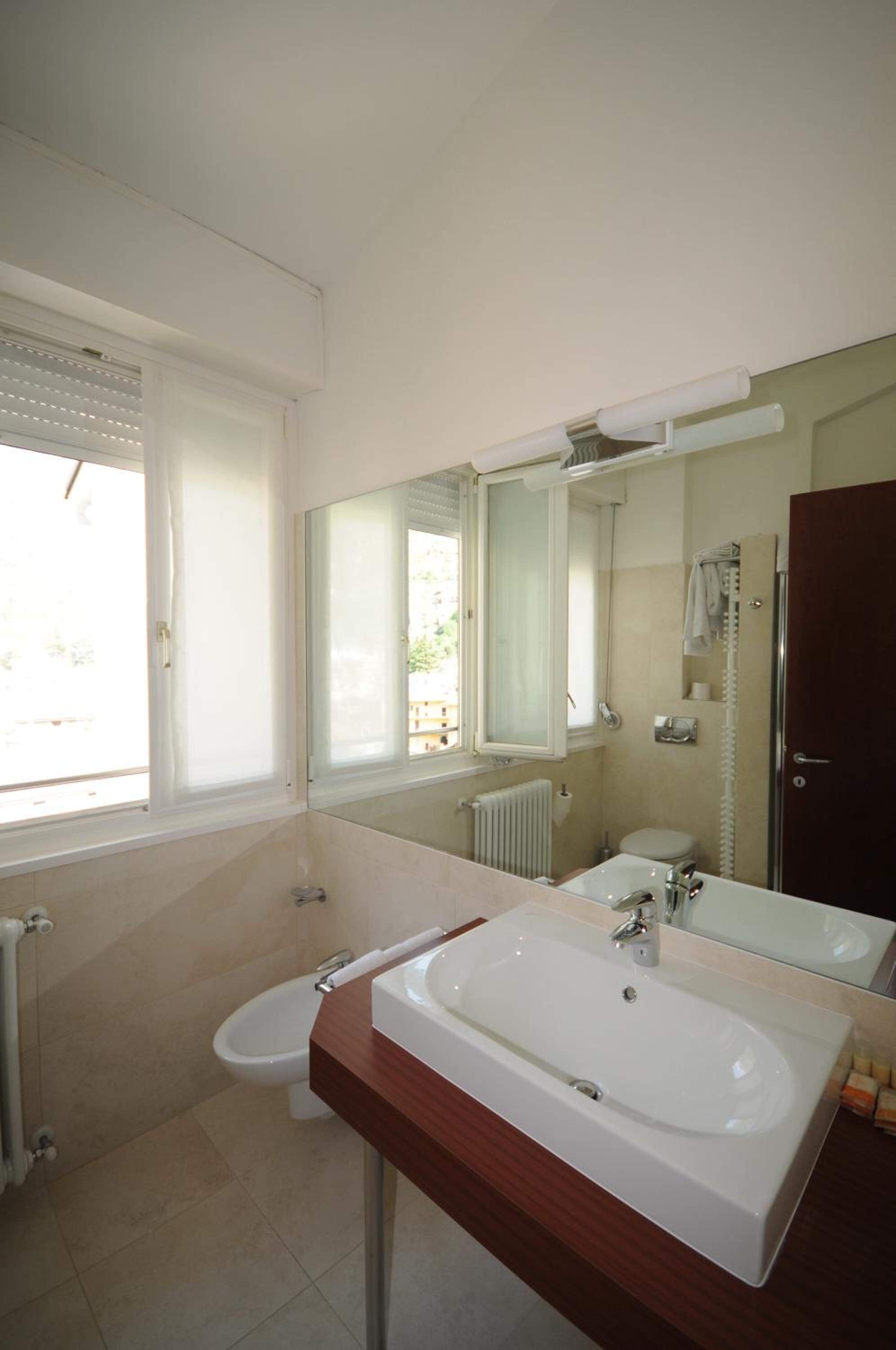 A modern bathroom with a large sink, a toilet, and a bidet.