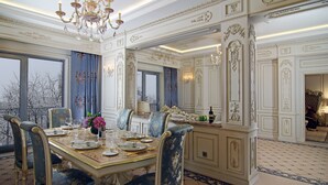 Een elegant eetgedeelte met decoratieve details, een kroonluchter en uitzicht op het omliggende landschap.