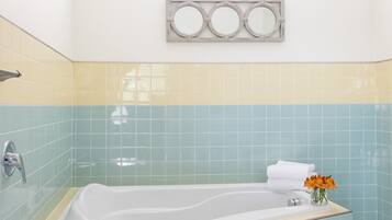 A bathroom with a freestanding bathtub, a shower, and a vanity with a mirror.