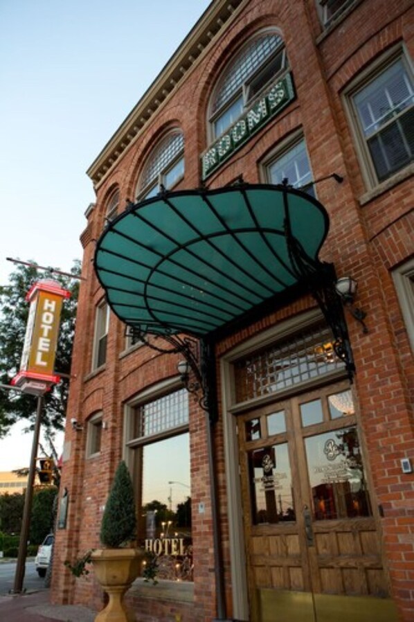 A brick building with a large awning and a sign that reads "HOTEL". - Retro Suites Hotel (Chatham-Kent)
