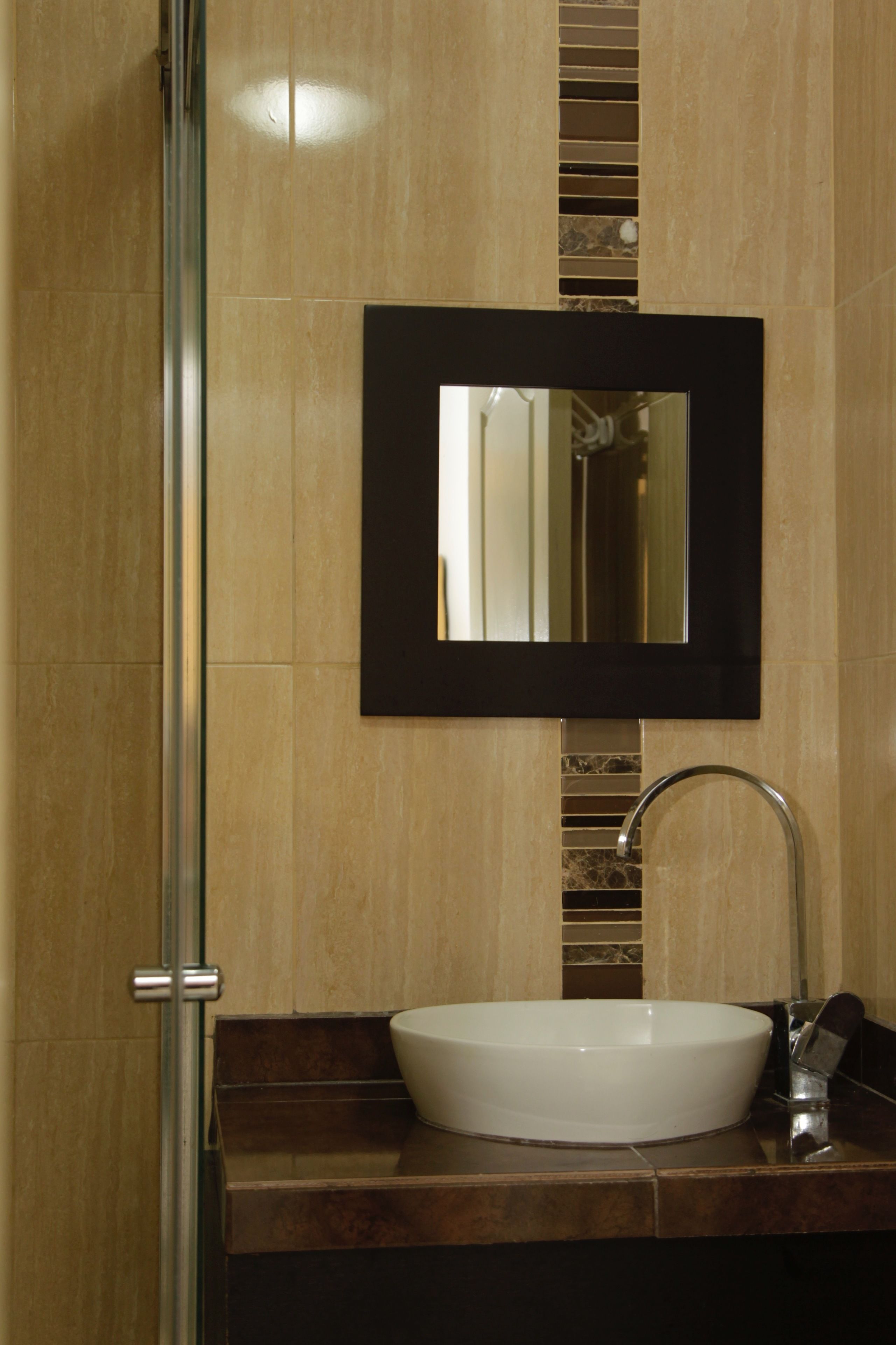 A bathroom with a white sink, a mirror, and a shower.
