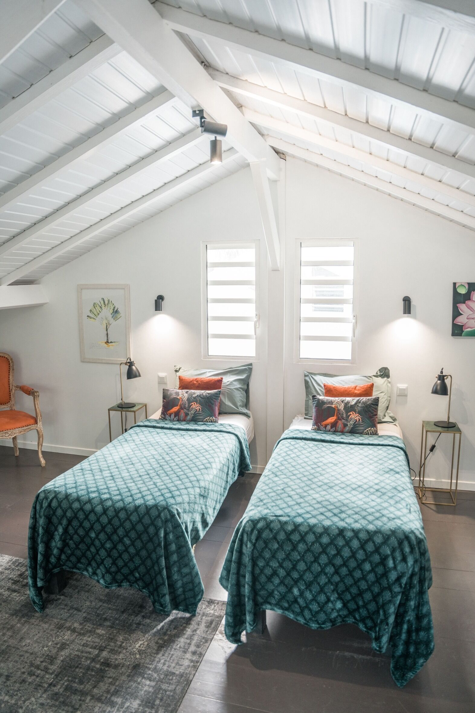 Un dormitorio con dos camas, una silla y una mesita.