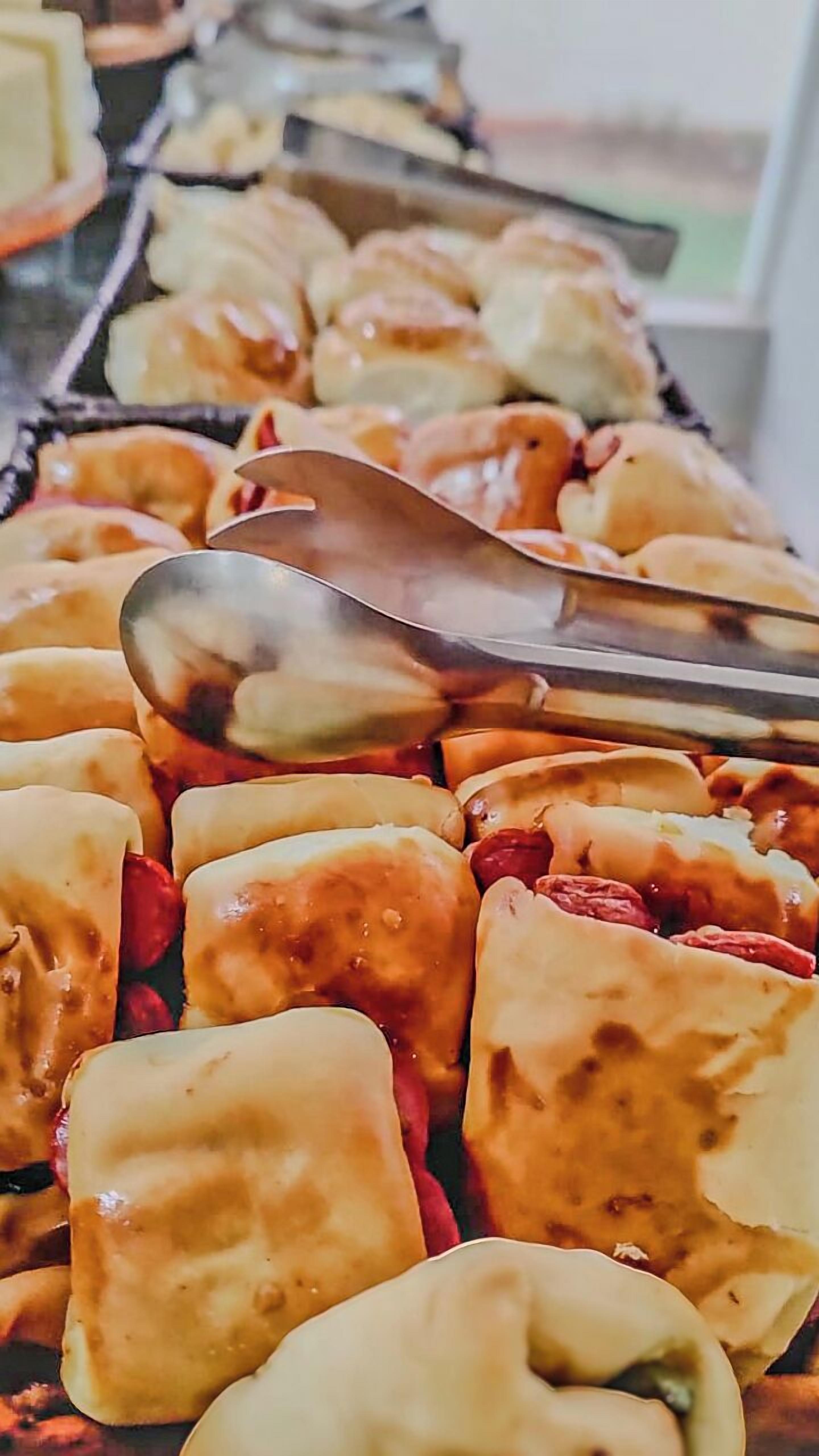A tray of pastries with a spoon on top.