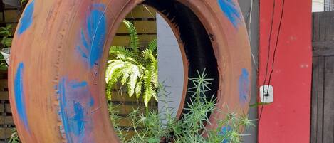 A tire hanging as a planter with flowers and plants.