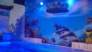 An indoor swimming pool with a mural of marine life. - Pousada Flora Búzios (Búzios)
