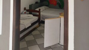 A room with a bed, a small desk, a ceiling fan, and a wall with a colorful flower mural. - Pousada Flora Búzios (Búzios)