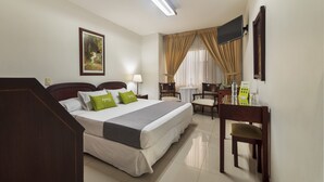 A hotel room with a bed, bedside table, lamp, chair, desk, and a television on the wall. - Ayenda 1408 Jaba Santiago de Cali (Cali)