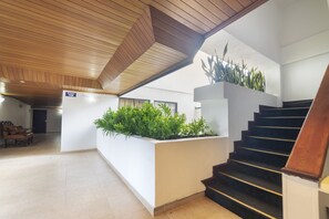 A modern interior with a wooden ceiling, a staircase, and a planter with green plants. - Ayenda 1408 Jaba Santiago de Cali (Cali)