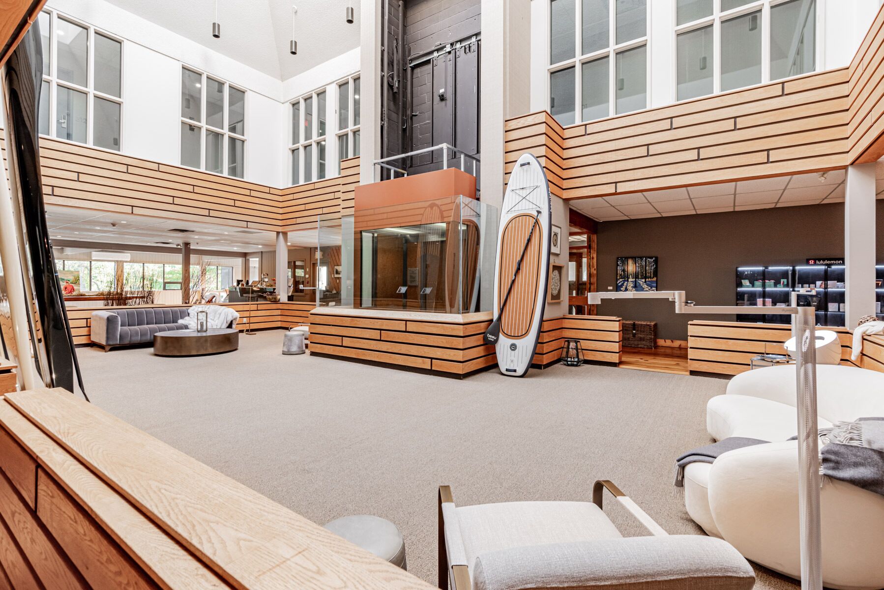 A spacious lobby with a central seating area, a reception desk, and a large window providing natural light.