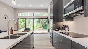 Una cocina moderna con un amplio ventanal, electrodomésticos de acero inoxidable y un diseño minimalista.