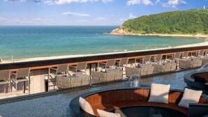 A deck with seating overlooking a beach and ocean. - Hotel Two - Y (Yangyang)