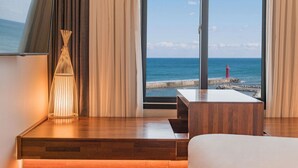 A hotel room with a large window offering a view of the sea and a lighthouse. - Hotel Two - Y (Yangyang)