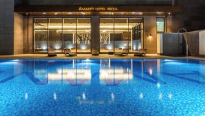 Una piscina interior con sillones de descanso frente al hotel Amanti Seoul.