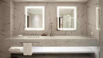 A modern bathroom with two sinks, a large mirror, and a vanity with a towel rack.