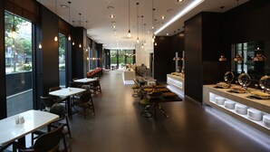 Un restaurante moderno con una barra larga, mesas y sillas.