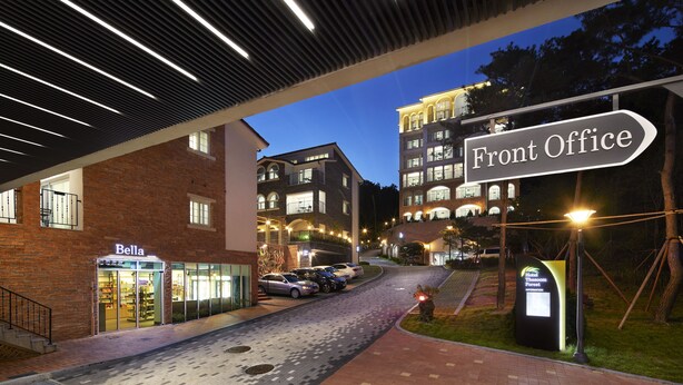 A hotel entrance with a "Front Office" sign, a "Bella" store, and a parking area. - The Soom Forest Hotel (Yongin)
