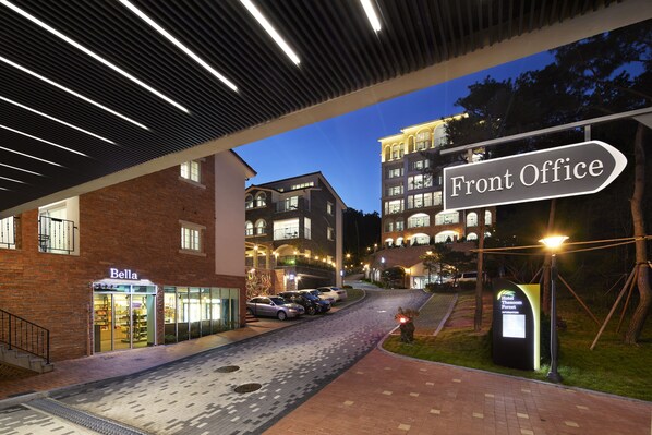 A hotel entrance with a "Front Office" sign, a "Bella" store, and a parking area. - The Soom Forest Hotel (Yongin)