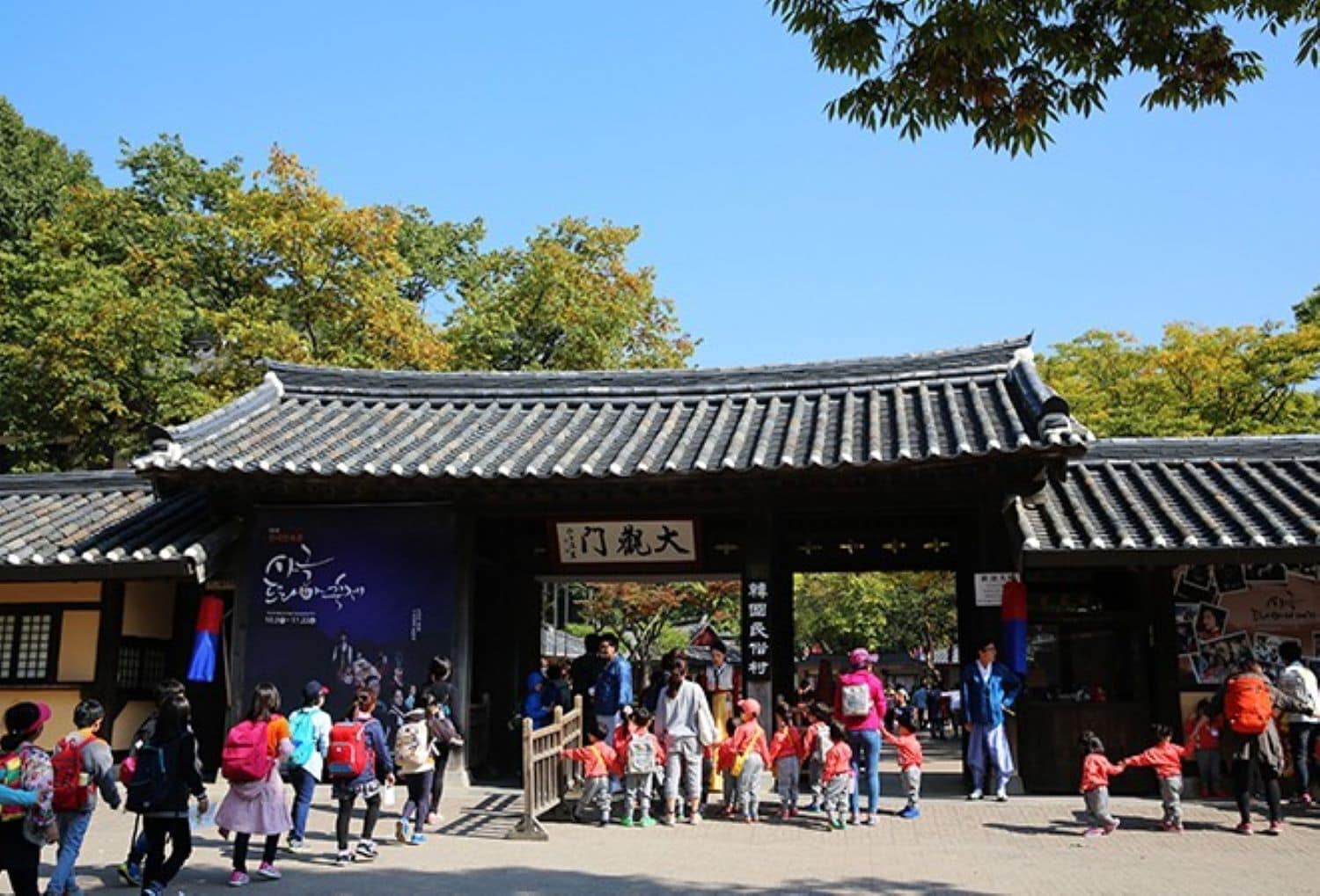 A traditional Korean gate with people walking through.
