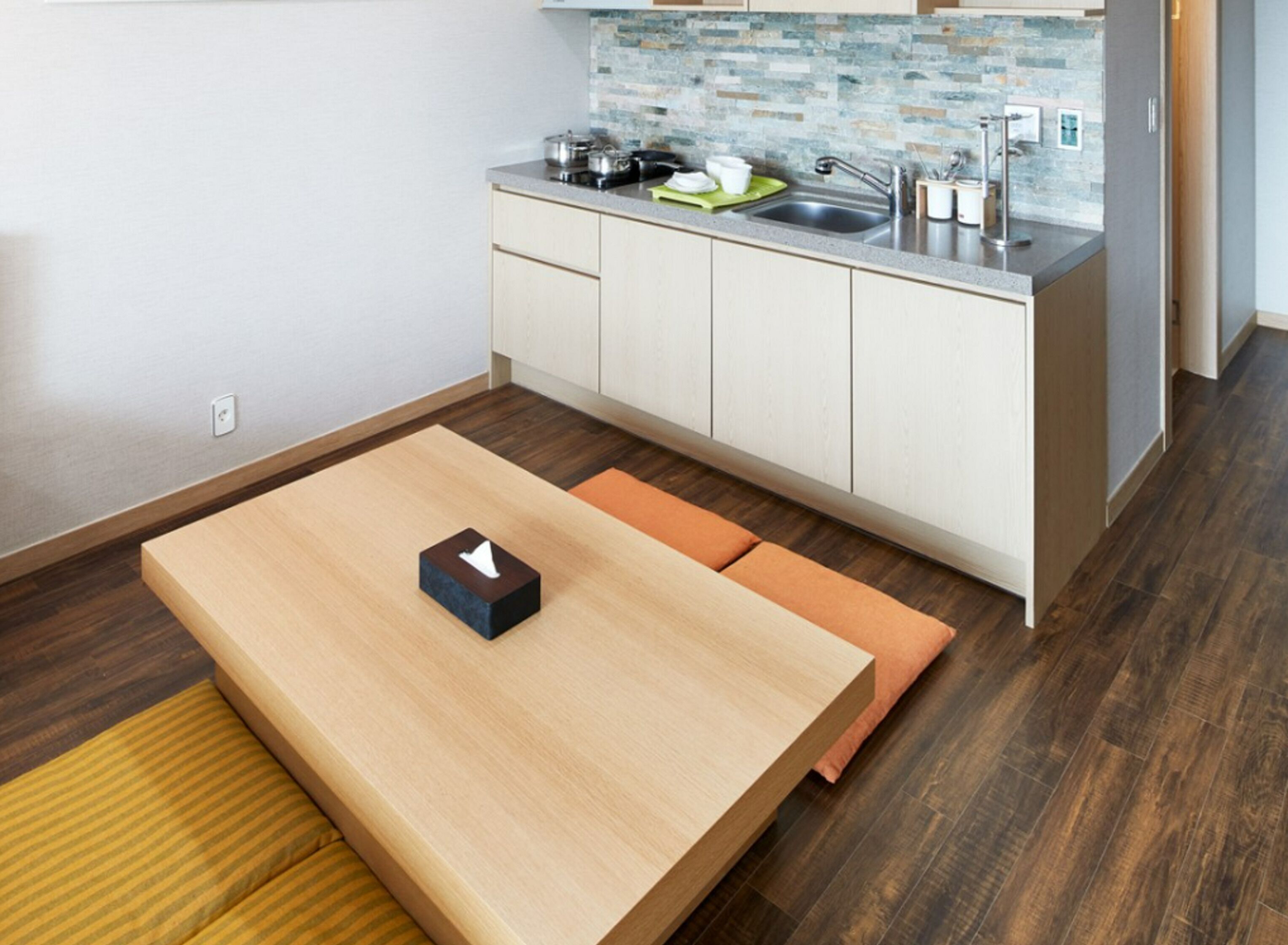 Una cocina moderna con una mesa de madera, un fregadero y una salpicadura.