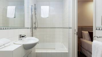 A modern bathroom with a glass-enclosed shower, a white sink, and a bathtub.
