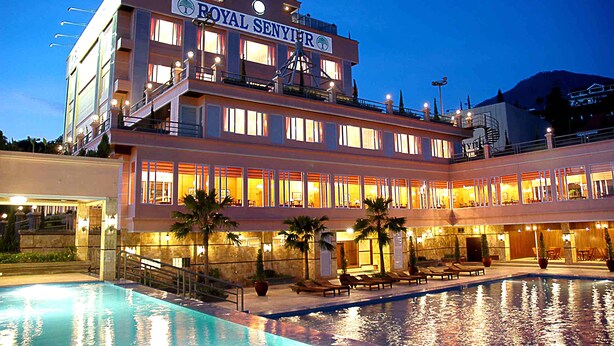 A hotel with a pool, multiple floors, and a sign reading "ROYAL SENYIR". - Royal Senyiur Hotel Pasuruan (Prigen)