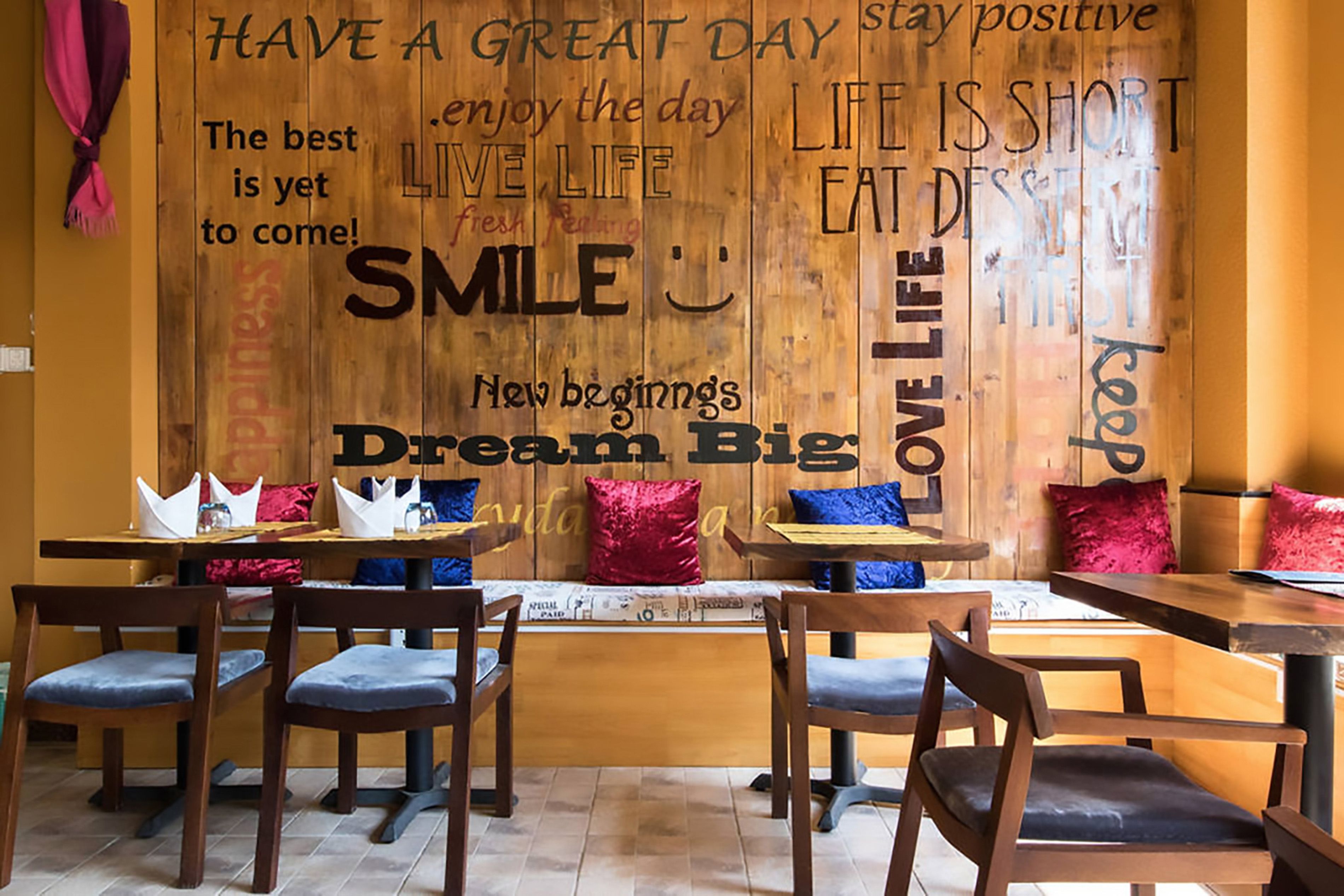 A restaurant interior with wooden walls, tables, and chairs.
