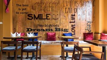 A restaurant interior with wooden walls, tables, and chairs.
