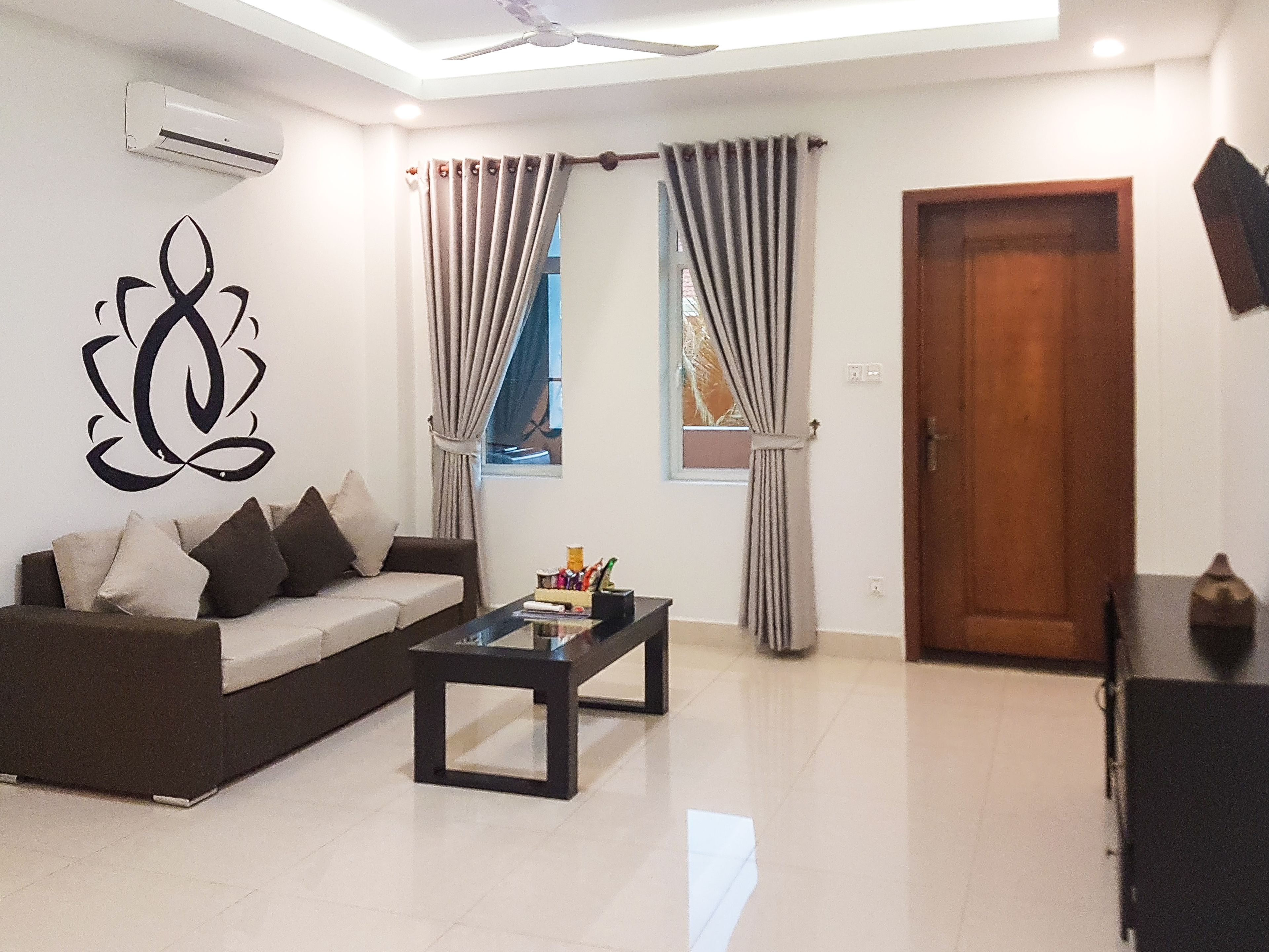 A living room with a sofa, a coffee table, and curtains.