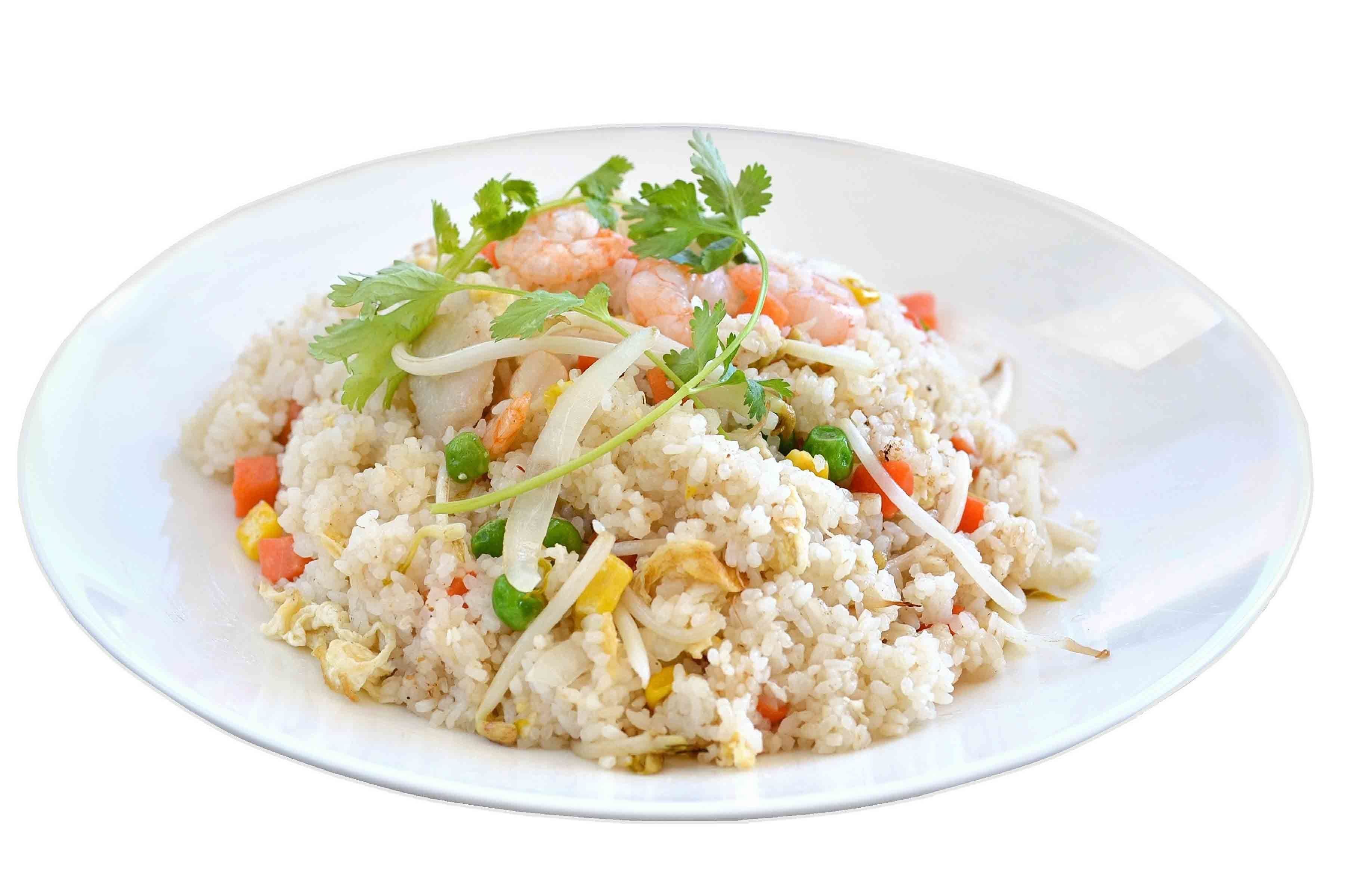 Une assiette de riz frit aux crevettes et aux légumes, garnie de coriandre.