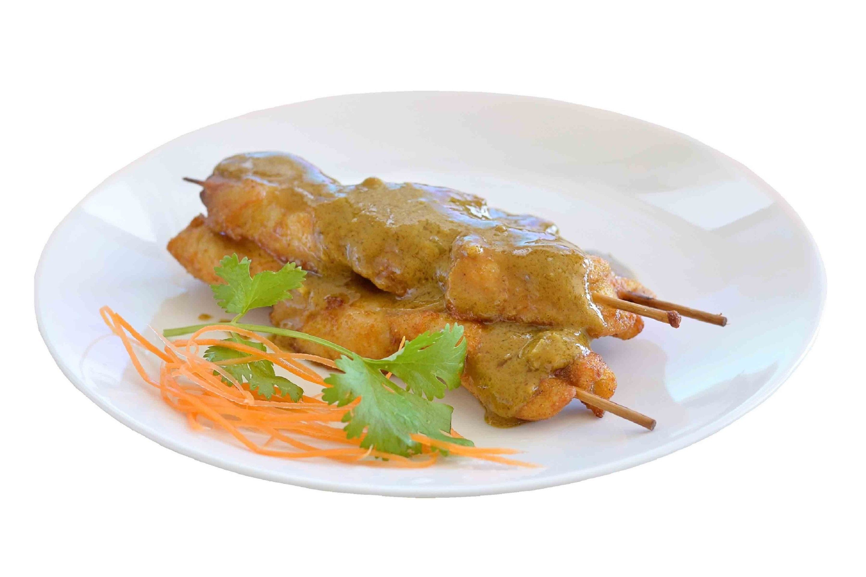 A plate of skewered meat with a sauce, garnished with cilantro and carrot shreds.